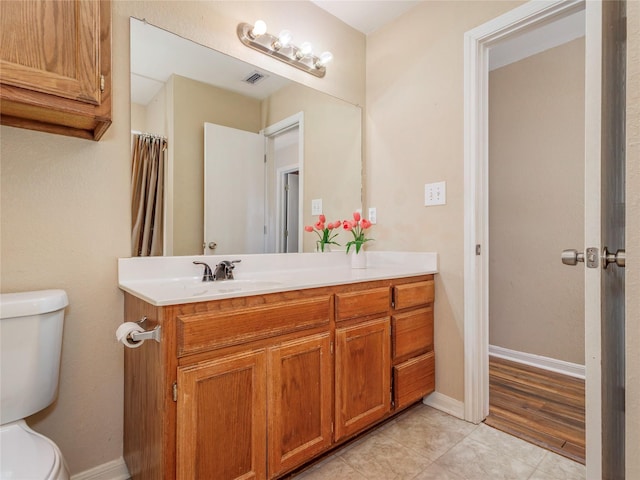 full bath featuring visible vents, toilet, tile patterned flooring, baseboards, and vanity