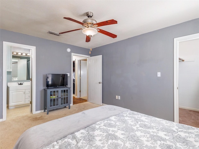 bedroom featuring a spacious closet, visible vents, ceiling fan, carpet, and ensuite bathroom