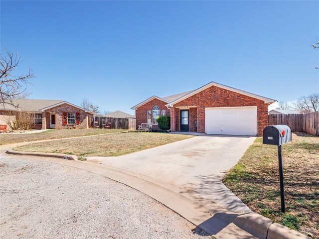 ranch-style home featuring brick siding, concrete driveway, a front yard, and fence