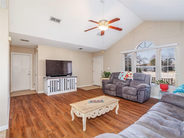 living room featuring visible vents, lofted ceiling, baseboards, and wood finished floors