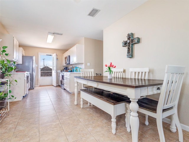 dining space with light tile patterned floors and visible vents