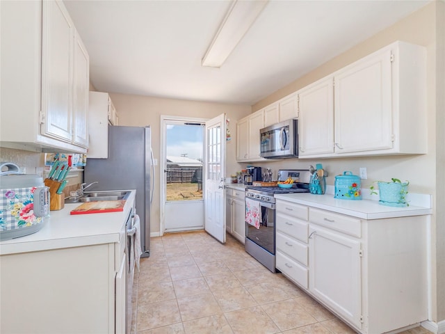 kitchen with light tile patterned floors, stainless steel appliances, light countertops, and white cabinetry