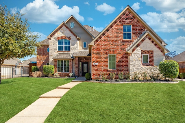 view of front of home featuring brick siding, a shingled roof, fence, a front yard, and stone siding