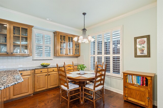 dining room with dark wood finished floors, a chandelier, and ornamental molding