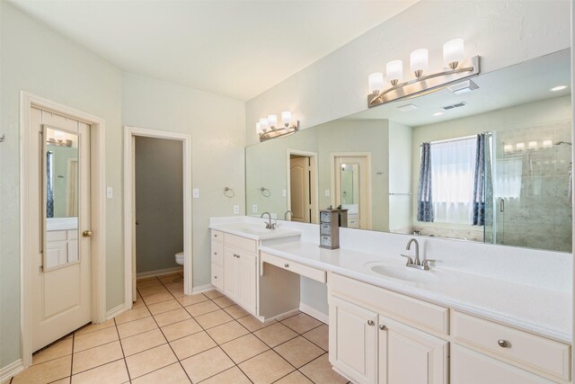 bathroom featuring double vanity, a stall shower, a sink, tile patterned floors, and toilet