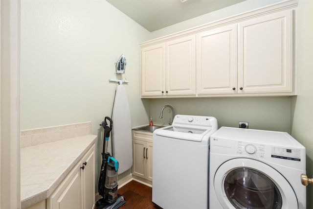 clothes washing area with washing machine and clothes dryer, cabinet space, dark wood-type flooring, and a sink