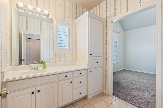 full bathroom featuring tile patterned flooring, wallpapered walls, baseboards, vaulted ceiling, and vanity