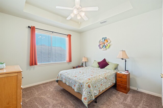 bedroom featuring a tray ceiling, baseboards, and visible vents