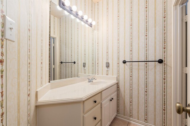 bathroom with wallpapered walls, vanity, and tile patterned flooring