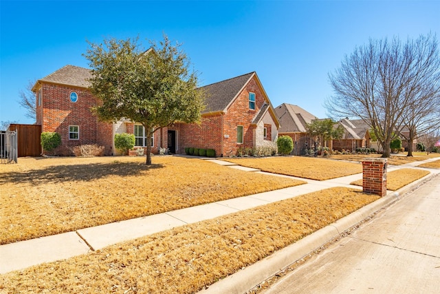 view of front of property featuring fence and brick siding