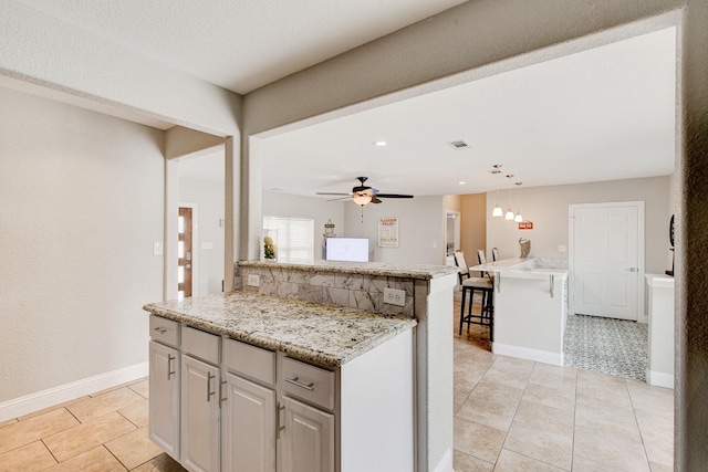 kitchen with decorative light fixtures, visible vents, a ceiling fan, and baseboards