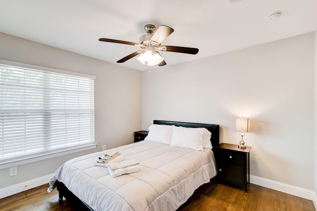 bedroom with a ceiling fan, baseboards, and wood finished floors