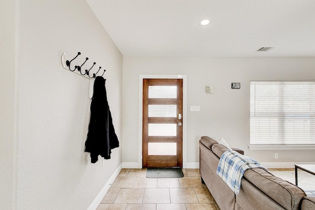 foyer entrance with plenty of natural light, baseboards, and light tile patterned floors