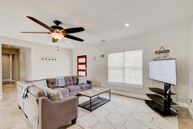 living room with ceiling fan, recessed lighting, baseboards, and a textured ceiling