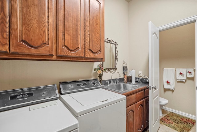 washroom featuring tile patterned floors, a sink, washing machine and dryer, baseboards, and laundry area