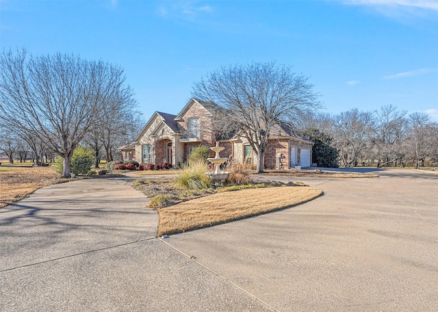 view of front of property featuring a garage, stone siding, and concrete driveway