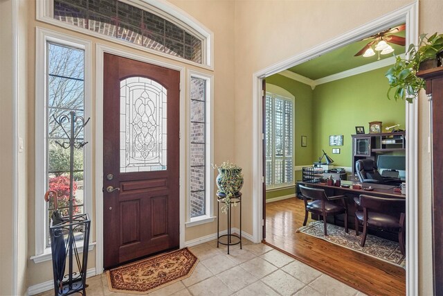 tiled foyer with baseboards and ornamental molding