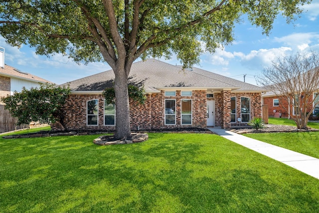 view of front of house featuring a front lawn, brick siding, and a shingled roof