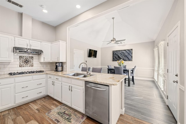 kitchen featuring a peninsula, lofted ceiling, a sink, stainless steel appliances, and under cabinet range hood