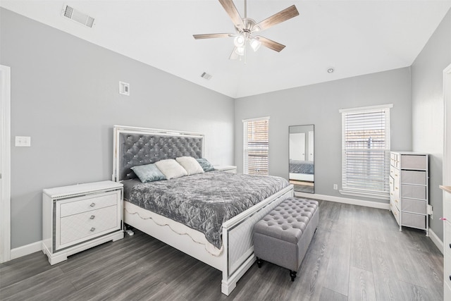 bedroom featuring visible vents, multiple windows, and dark wood finished floors