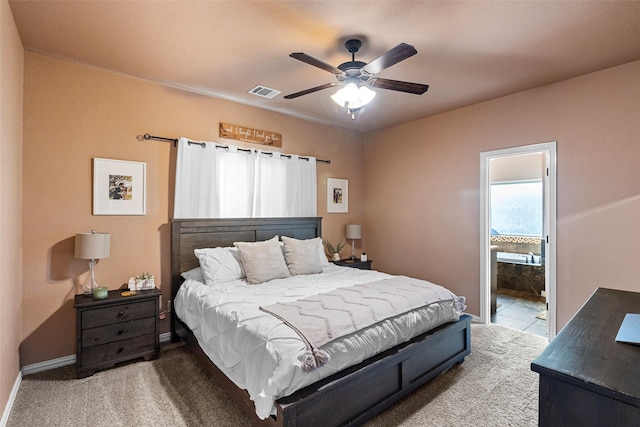 carpeted bedroom featuring visible vents, baseboards, ensuite bath, and a ceiling fan