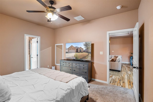 bedroom with visible vents, baseboards, light colored carpet, and a ceiling fan