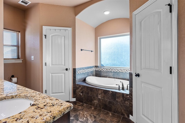 full bath featuring vanity, a garden tub, and visible vents