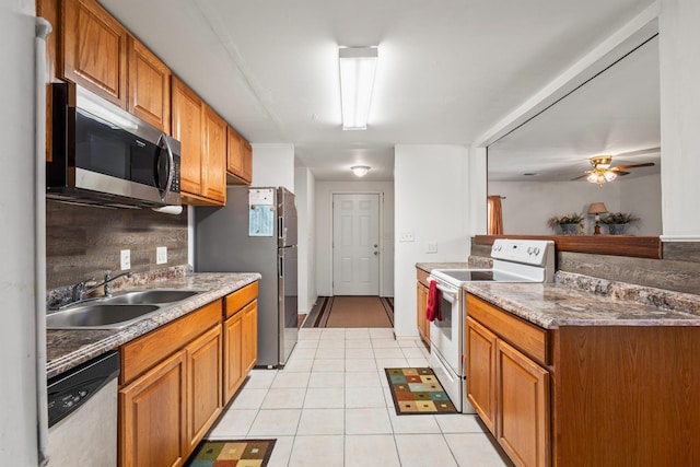 kitchen with brown cabinetry, appliances with stainless steel finishes, and a sink