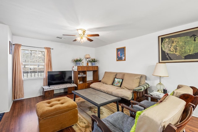 living area featuring visible vents, baseboards, ceiling fan, and wood finished floors