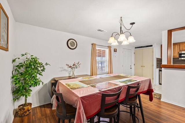 dining space with wood finished floors and visible vents