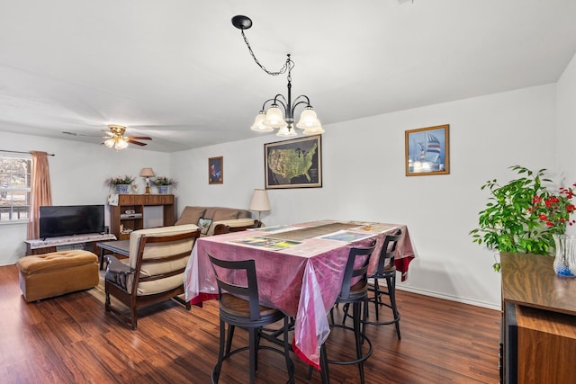 dining area with ceiling fan with notable chandelier, dark wood-style floors, and baseboards