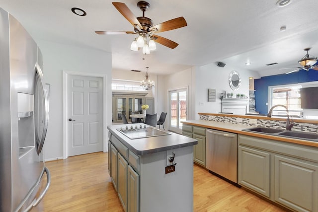 kitchen featuring a sink, stainless steel appliances, light wood-type flooring, and a wealth of natural light