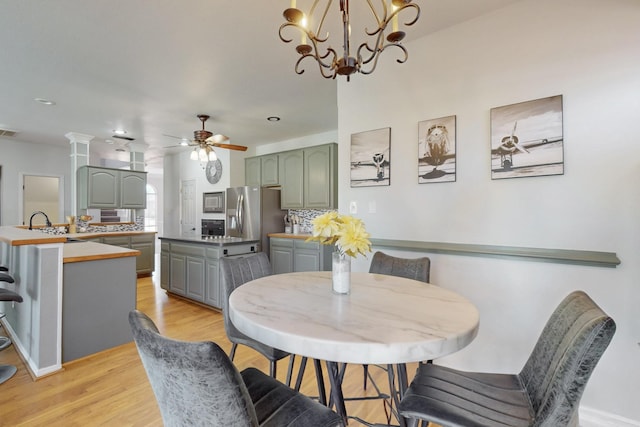 dining area featuring light wood finished floors, visible vents, and ceiling fan