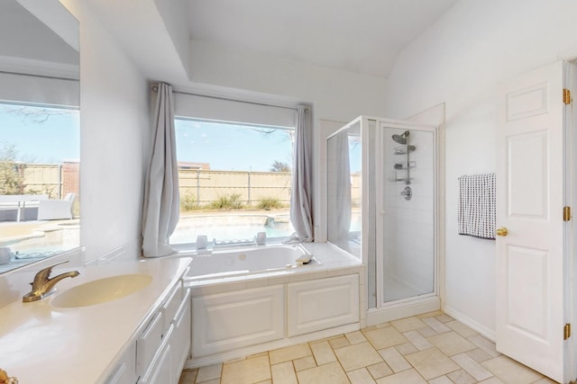 bathroom with a shower stall, vanity, lofted ceiling, and a garden tub