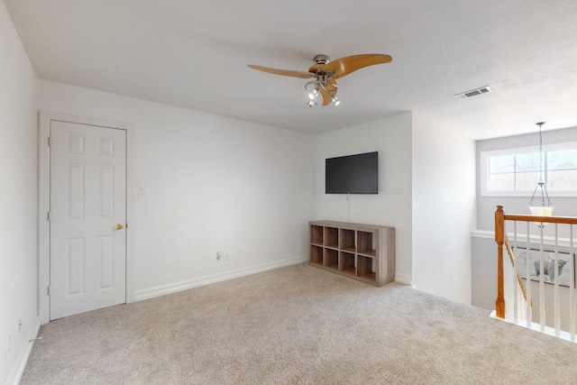 unfurnished living room with visible vents, carpet, and ceiling fan