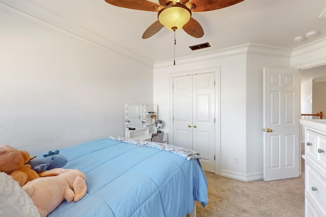 bedroom with visible vents, light carpet, a closet, crown molding, and ceiling fan