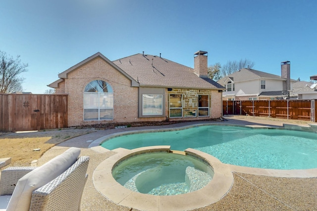 view of pool featuring a fenced backyard and a pool with connected hot tub