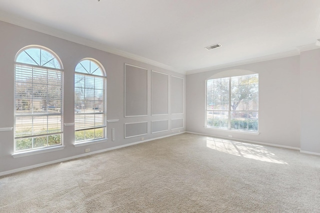 spare room featuring visible vents, carpet, and ornamental molding