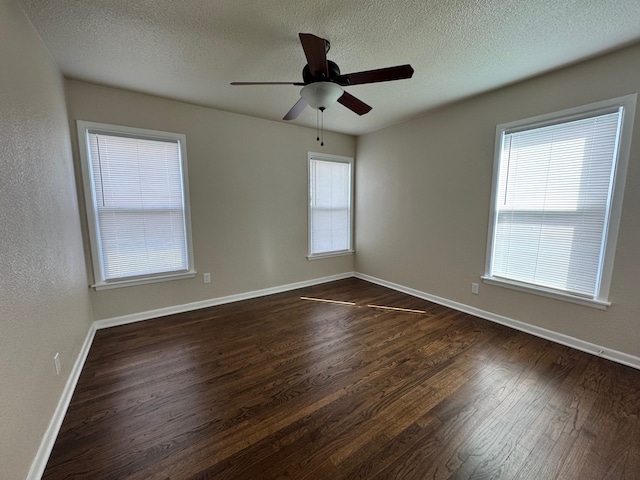 spare room with a ceiling fan, dark wood-style floors, baseboards, and a textured ceiling