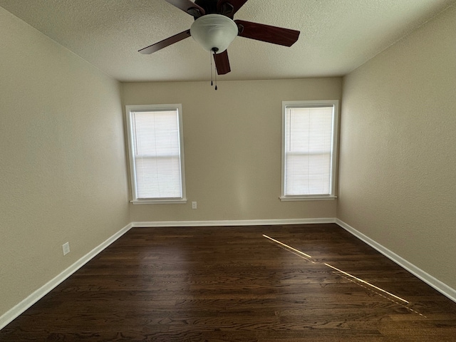 unfurnished room featuring a wealth of natural light, baseboards, and dark wood finished floors