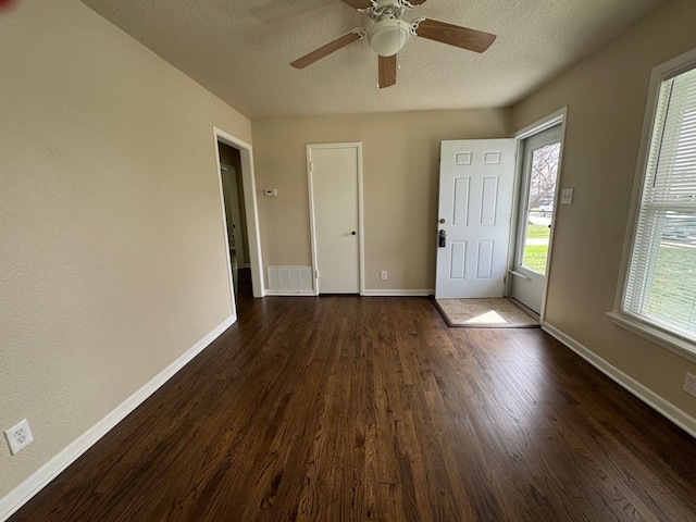 entryway with visible vents, ceiling fan, baseboards, a textured ceiling, and dark wood-style flooring