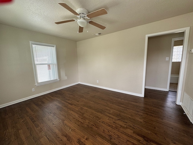 spare room with plenty of natural light, dark wood-type flooring, and baseboards