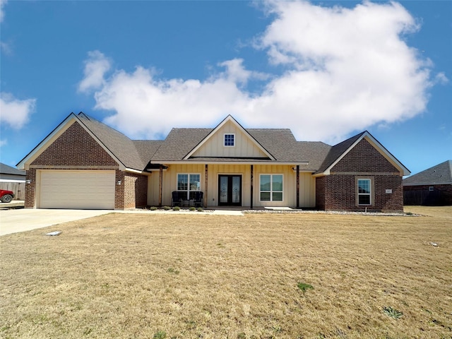 view of front of property with board and batten siding, a front lawn, french doors, and a garage