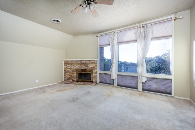 unfurnished living room with vaulted ceiling, carpet flooring, baseboards, and a textured ceiling