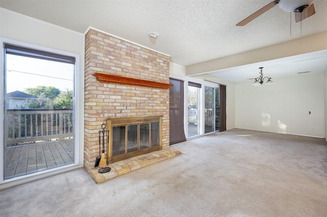 living area featuring plenty of natural light, carpet flooring, a fireplace, and a textured ceiling