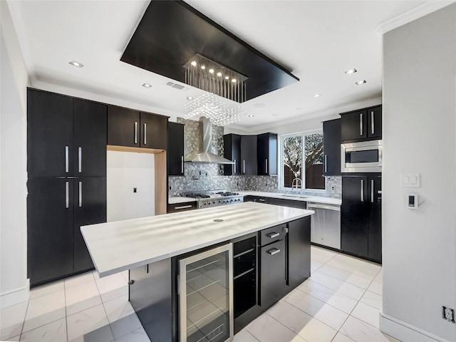 kitchen with stainless steel appliances, wine cooler, dark cabinetry, and wall chimney exhaust hood