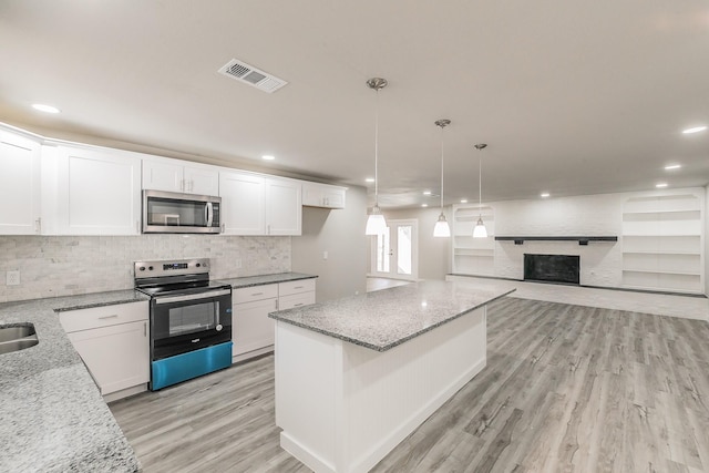 kitchen with white cabinets, visible vents, backsplash, light wood-style floors, and appliances with stainless steel finishes
