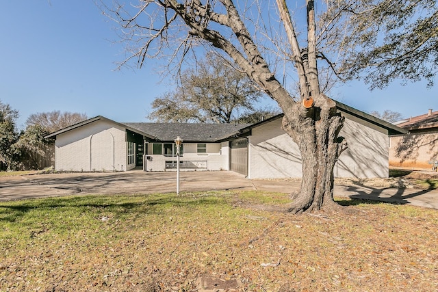 ranch-style house with driveway and a front lawn