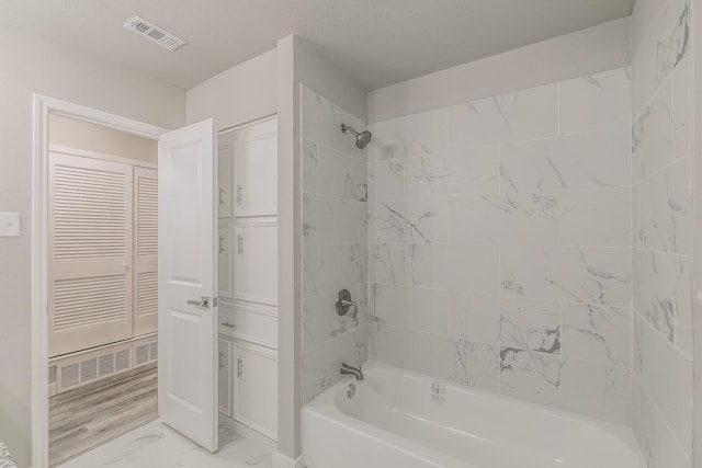 full bathroom with marble finish floor, bathtub / shower combination, and visible vents