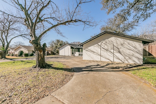 view of yard with driveway and fence